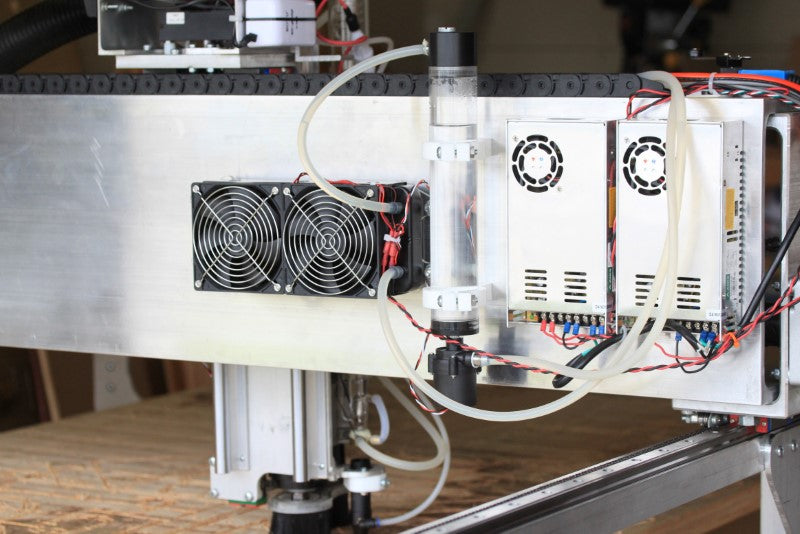 Fabricator Pro CNC Router view of the back of the gantry showing the two power supply for the stepper motors and drivers and the CO2 water cooling with the pump and radiator fan.