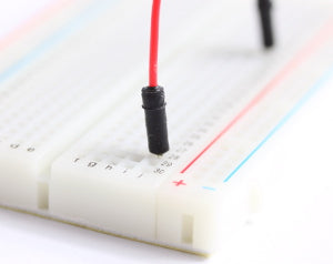 A single male to male jumper wire connected at both ends into a breadboard. 