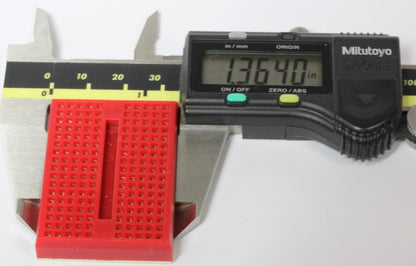 A mini breadboard inside of a caliper, showing the width. 